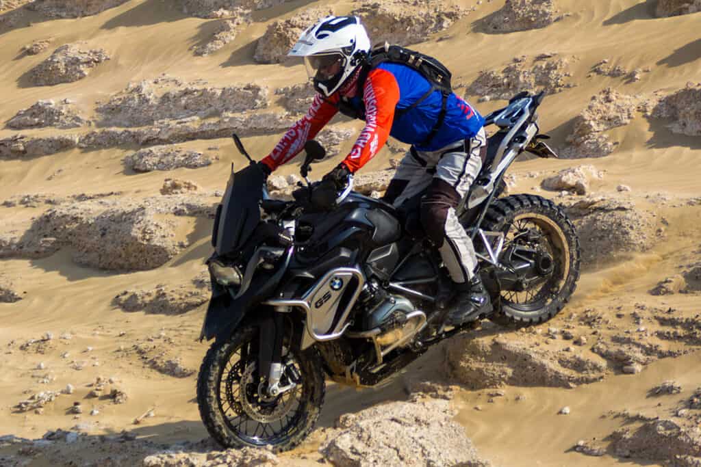 Photo shows proper body positioning and motorcycle ergonomics of a BMW R1200GS motorcycle riding on off-road terrain