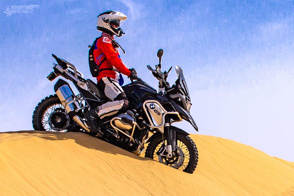 Motorcycle rider sitting on BMW 1200GS motorcycle on a sand dune
