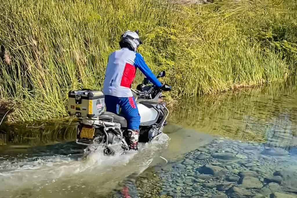 ADV motorycle rider performing water crossing